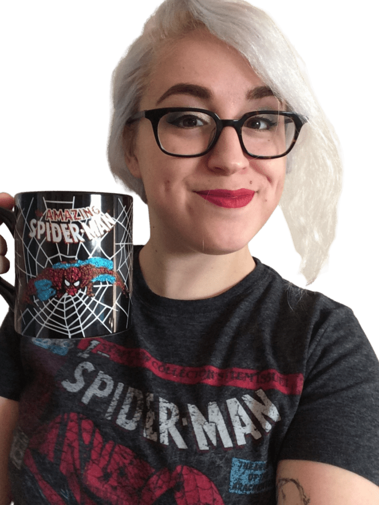 Claire smiling, holding a Spiderman coffee mug, and wearing a Spiderman t-shirt
