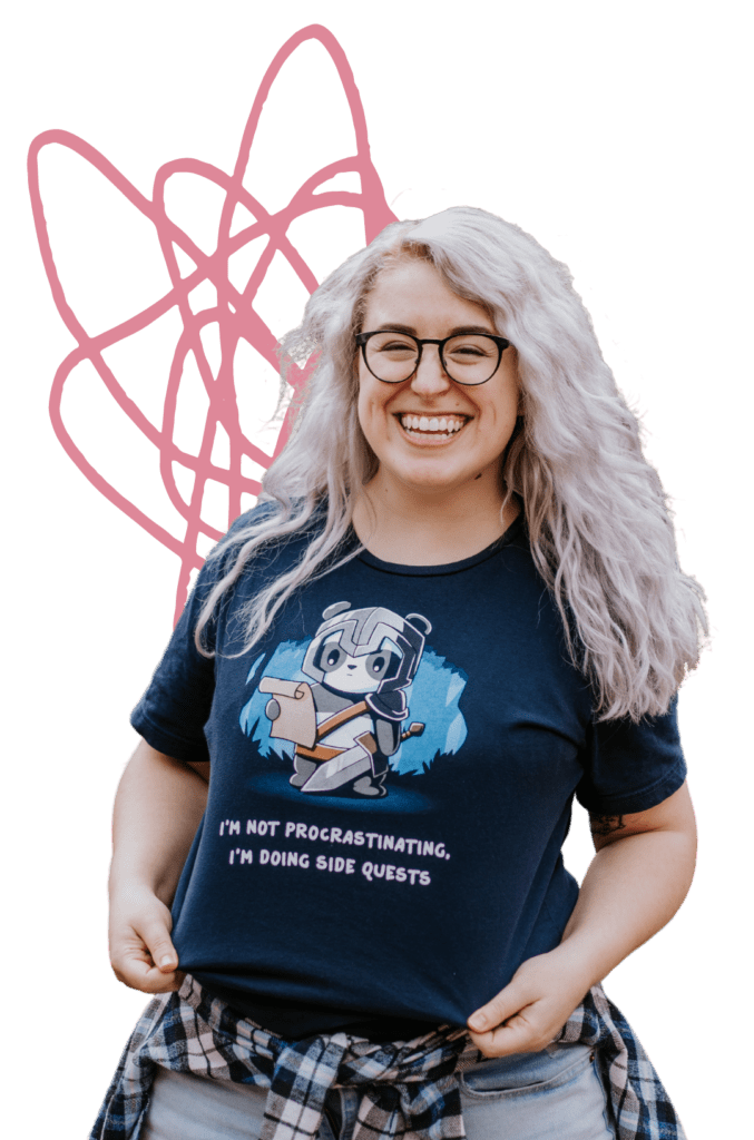 Claire grinning and showing off her t-shirt, which says "I'm not procrastinating, I'm doing side quests"